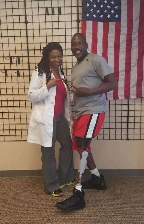 man standing with medical professional showing off his new prosthetic leg